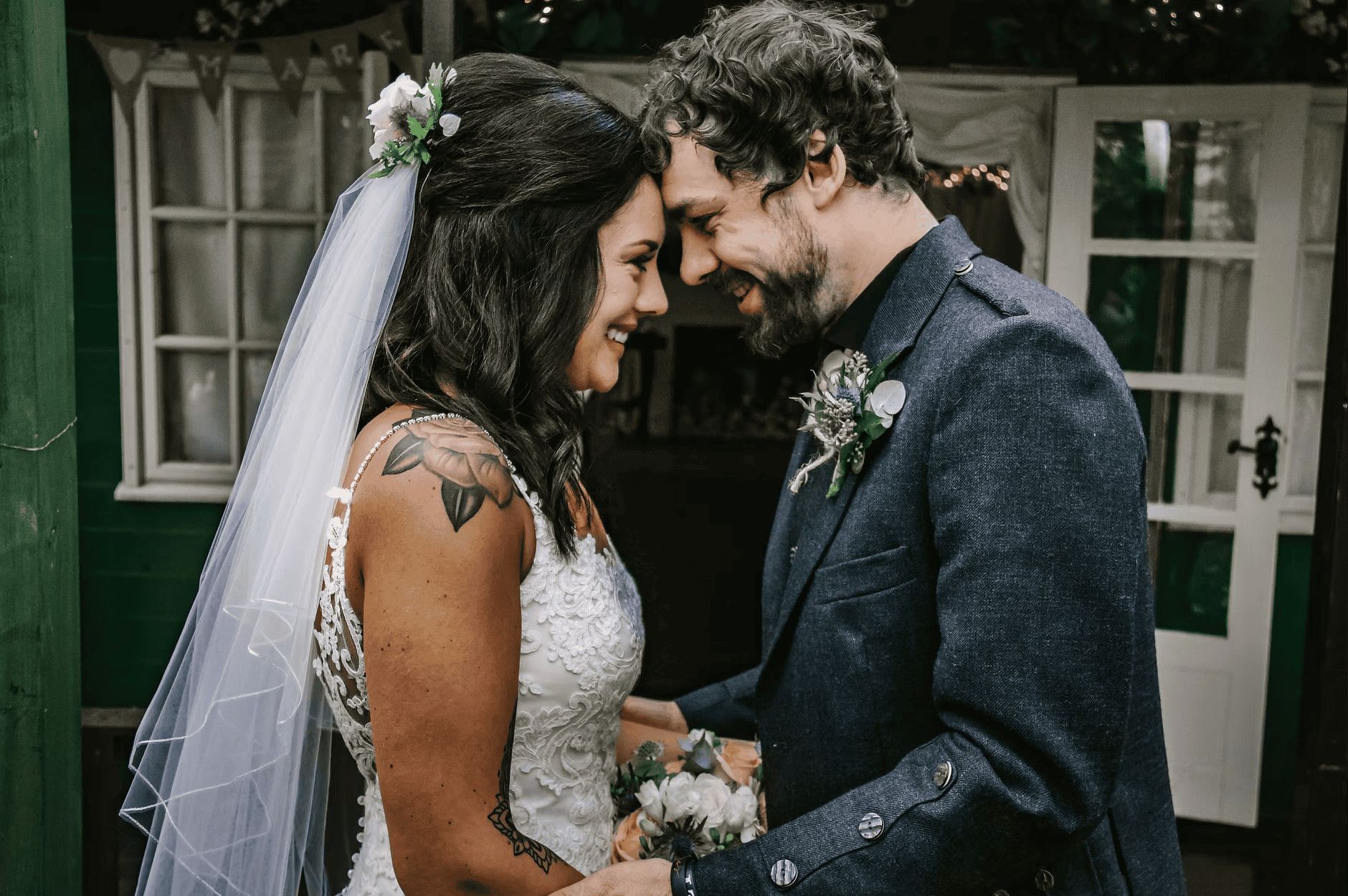 Bride and groom share a laugh in a rustic bohemian outdoor venue